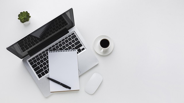 person comparing options on paper decision grid with laptop